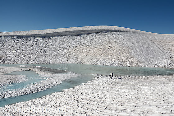 Foto: Fotograf am Gletschersee in weiter, schneebedeckter Landschaft.