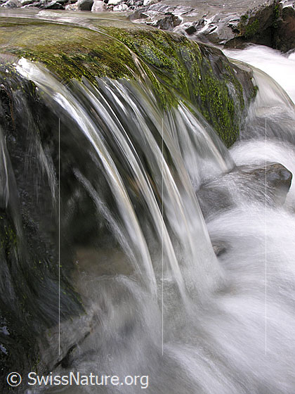 Foto: Am Oberlauf der Emme: Wasser fliesst über einen kleinen Felsvorsprung. Kleiner Wasserfall.