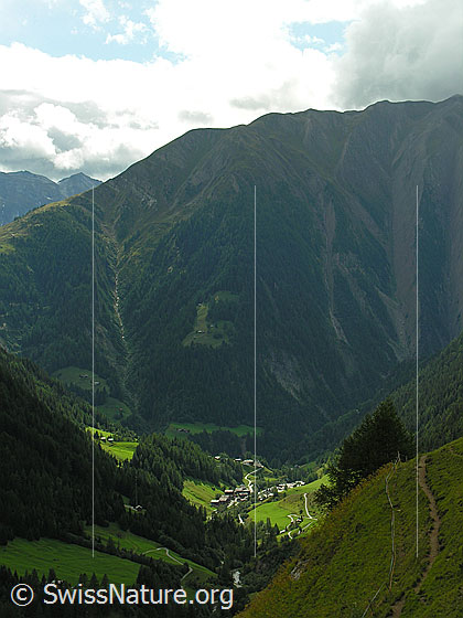 Foto: Blick über das Binntal.Das Bergdorf Binn wird wie von einem Schweinwerfer beleuchtet. Im Hintergrund das Breithorn.
