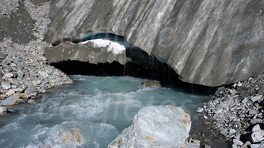 Foto: Es enstpringt die Lonza. Aus dem breiten Gletschertor des Langgletschers fliesst Gletschermilch. Über die Eisoberfläche rinnt Schmelzwasser in zahlreichen Tropfen in den Gletscherbach.
