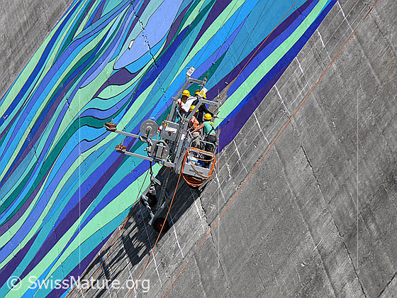Foto: Die Künstler an der Arbeit.
Staumauer mit Gemälde. Räterichsboden-Staumauer mit Gemälde "Mélisande" des Künstlers Pierre Mettraux.