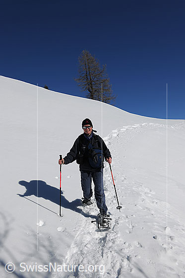 Foto: Schneeschuhläuferin im Abstieg.