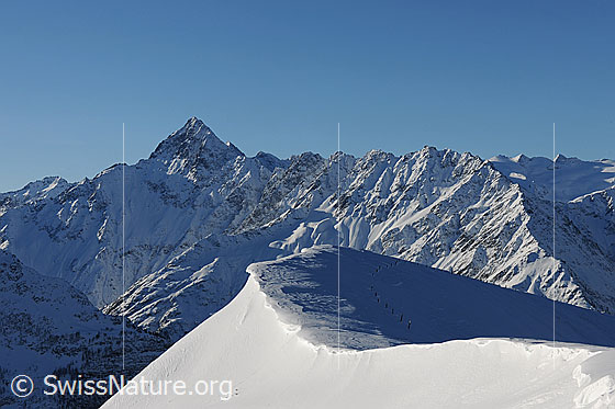 Foto: Wächte auf Planplatten und verschneite Berglandschaft mit Ritzlihorn und dem langezogenen, zerfurchten Grat mit Schaflägerstöck, Gallauistöck und Bättlerhorn. Im Hintergrund ist der Alplistock zu sehen und rechts im Bild der Gauligletscher.