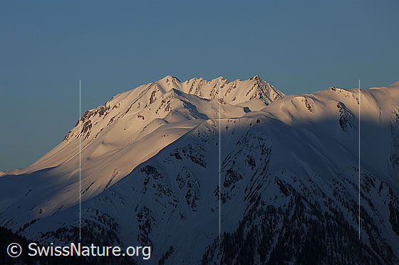 Foto: Morgenstimmung in den Bergen.
Berggipfel mit Schnee im Morgenlicht. Zu sehen sind Breithorn, Milihorn und Bättlihorn.