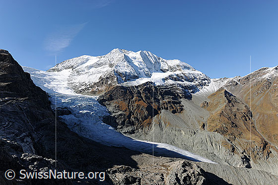 Foto: Turtmanngletscher, Les Diablons und Diablonsgletscher mit Licht und Schatten. Die Gipfel sind frisch verschneit und die Berghänge zeigen sich in den Herbstfarben. Deutliche Seitenmoränen zeugen vom einst mächtigen Gletscher.