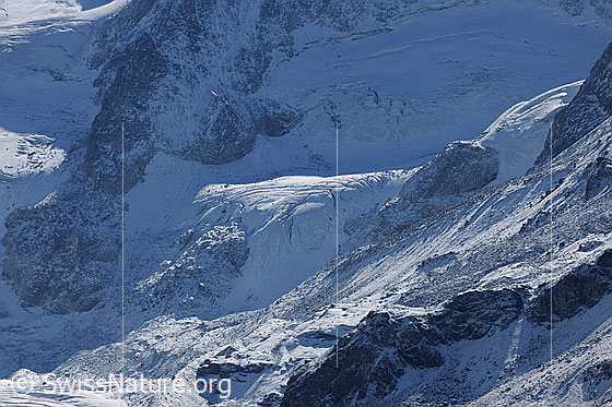 Foto: Gletscher am Fuss der Pointes de Mourti. In die Gletscherlandschaft fällt Licht und Schatten. Die Felspartien sind mit wenig Schnee überpudert.