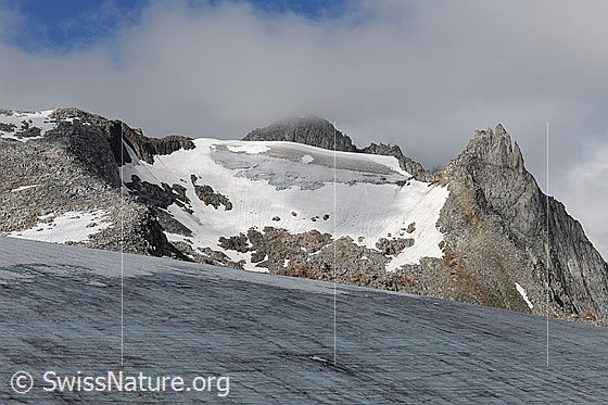 Foto: Chüebodengletscher und Poncione die Manio mit Restwolken. Der Gletscher ist ausgeapert und in der Bergflanke haftet nur noch ein Gletscherrest.