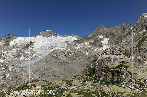 Foto: Albert-Heim-Hütte, Tiefengletscher und Galenstock. Die Gletscherzunge ist leicht mit Geröll bedeckt. Über der Bergütte ist das Gletschhorn mit dem Gletscherrest das Sunniggletschers zu sehen.