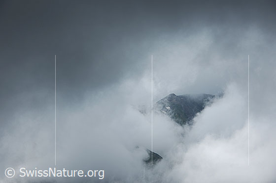 Foto: Breithorn in Wolken gehüllt. Durch eine Wolkenlücke ist ein Vorgipfel des Breithorns zu sehen.