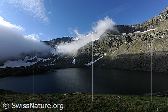Foto: Wolkenstimmung über dem Sirwoltesee. Licht und Schatten prägen die Berglandschaft um den See. Diese Stimmung war der Lohn für einen längeren Aufstieg durch den Nebel.