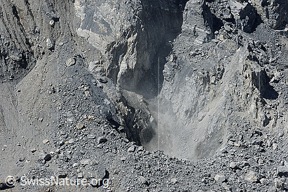 Foto: Steinschlag im Felssturzgebiet. Die heruntergefallenen Felsbrocken wirbeln Staub auf.