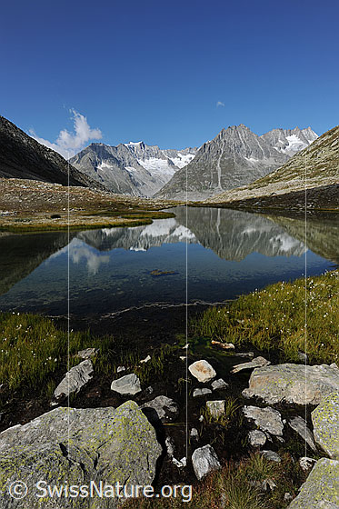 Foto: Bergsee mit Spiegelung der Berglandschaft im ruhigen Wasser. 
Berge im Hintergrund: Zenbächenhorn, Geisshorn, Olmenhorn und Dreieckhorn.