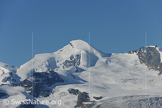 Foto: Allalinhorn und Feegletscher. 
Auf dem Gletscher ist ein Teil des Skigebiets von Saas Fee erkennbar.