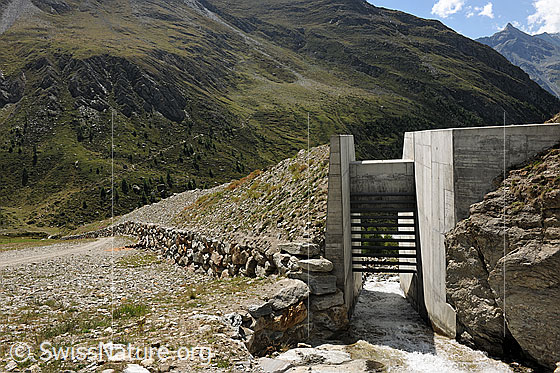 Foto: Schutzwall mit Durchlass für Bergbach. Bau zum Schutz vor Naturgefahren (Lawinen, Murgänge).
