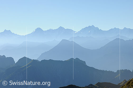 Foto: Silhouetten mehrerer Bergketten mit feinem Dunst. Im Hintergrund sind Eiger, Mönch und Jungfrau erkennbar.