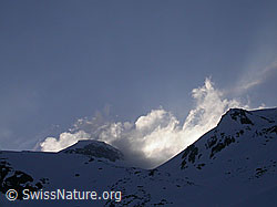F010097: Wolkenfetzen und Schneefahnen über dem Hotäl