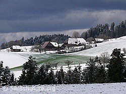 F045840: Dunkle Wolken über Winterlandschaft mit Bauernhof