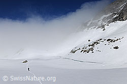F108315: Alpinwanderer unterwegs auf weiter Hochebene mit Wolkenstimmung